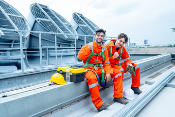Two engineer or technician worker sit together to relax after finish their work and look at camera with smiling and show action of happy to work.