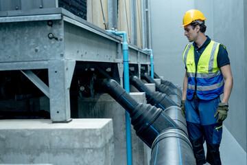 Engineer or technician worker walk and check pipe system of factory building.