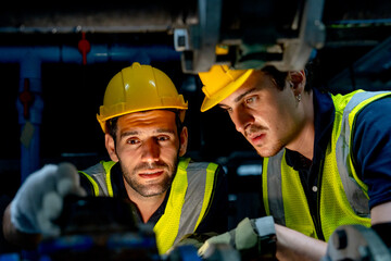 Close up and front view engineer or technician worker check valve system of factory building also stay under the system structure.