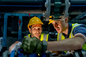 Close up engineer or technician worker check valve system of factory building also stay under the system structure.