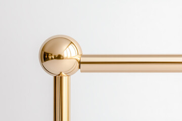 Close-up of a shiny gold railing component with a spherical end, emphasizing its smooth, reflective surface and minimalist aesthetic against a plain white background.