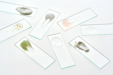 Textures of various cosmetic products on slides.