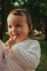 Happy little baby girl playing in a sunny park. Childhood joy, Mother's Day, outdoor activity,...