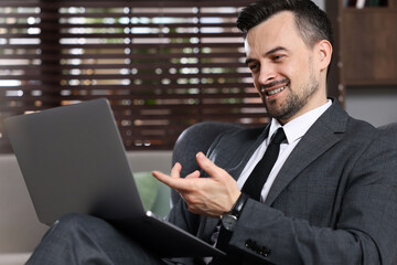 Professional psychologist having online consultation with his client via laptop indoors