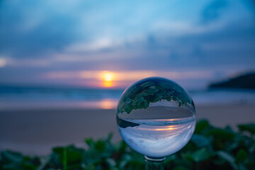 A captivating sunset reflected through a crystal ball, creating an inverted and artistic...