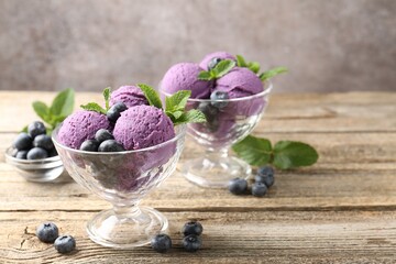 Tasty sorbet with blueberries and mint in dessert bowls on wooden table against grey background,...
