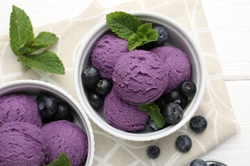 Tasty sorbet with blueberries and mint in bowls on white wooden table, top view