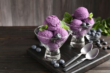 Tasty sorbet with blueberries and mint in dessert bowls on wooden table, closeup