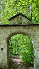 Brama Siedlecka gate in Dolina Eliaszowki, Krzeszowice, Lesser Poland Voivodeship, with lush green spring forest in the background. Historic site, Polish landmarks, nature, travel, cultural heritage. 