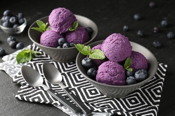Tasty sorbet with blueberries and mint on black table, closeup