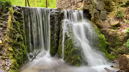 Fragment of Diabelski Most bridge and waterfall in Dolina Eliaszowki, Lesser Poland Voivodeship, Krakow, Poland. Nature, hiking, Polish landscape, travel destination, scenic forest, outdoor adventure. © Krystsina_Semianiuk