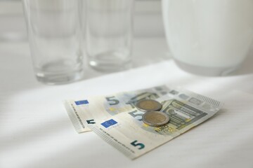 Tips on white wooden table, closeup. Gratuity for work