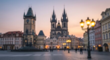 Obraz premium Blurred view of Prague's Old Town Square at dusk, featuring the Tyn Church and Astronomical Clock Tower.