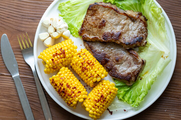 High Angle View of Grilled Meal of Steak, beef,corn and Vegetables Spread Out on Rustic Wooden Table