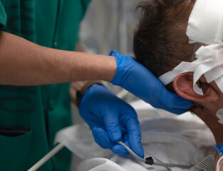 Doctor placing a central venous catheter into a patient's neck