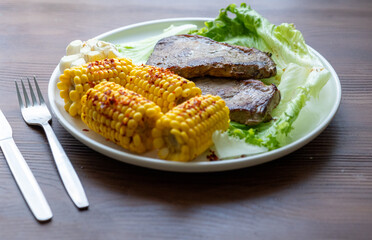 High Angle View of Grilled Meal of Steak, beef,corn and Vegetables Spread Out on Rustic Wooden Table