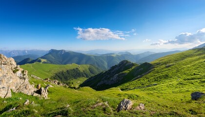 Obraz premium scenic landscape of rolling green hills and rocky cliffs under a bright blue sky in a tranquil mountainous region