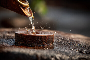  Close-up of Ganga water dripping from copper vessel onto Shivling during Abhishek.
