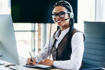 Confident businesswoman wearing headset in modern office at work, representing professionalism and...