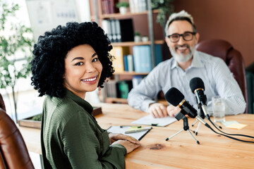 Professional podcast recording session with diverse team working collaboratively in a modern office environment