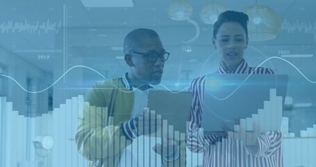 Analysts in mustard jacket striped blouse reviewing chart overlays on laptop in office with folder