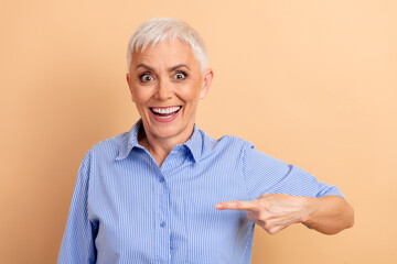 Energetic senior woman cheering with a enthusiastic gesture, wearing a striped shirt and showcasing...