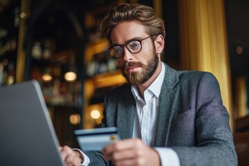 Attractive man with a credit card working on a laptop