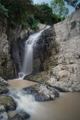 Fototapeta premium Spectacular waterfall cascades down rugged cliffside with lush greenery and surrounding water bodies creating a serene and dynamic natural scenery
