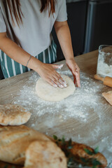 Young caucasian woman making bread dough with rolling pin and flour	
