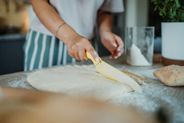 Young caucasian woman making bread dough with rolling pin and flour	
