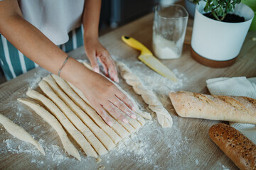 Young caucasian woman making bread dough with rolling pin and flour	
