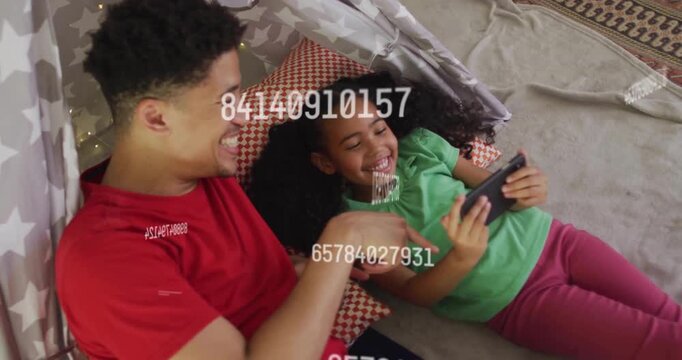 Daughter tapping smartphone in tent while father pointing animated data overlay for tech learning