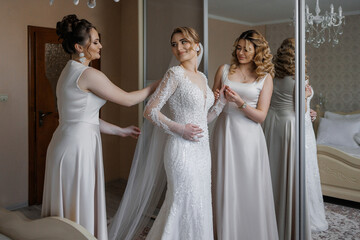 Friends assist bride in preparing for wedding ceremony in elegant home setting