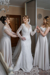Bridesmaids helping the bride prepare for her wedding day in a cozy room