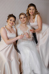 Bridal party celebrating with drinks in elegant dresses before the wedding ceremony