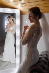 Elegant bride preparing for her special day in a beautifully lit room with a mirror