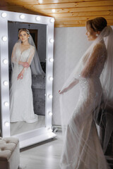 Bride admiring her reflection in a beautifully lit mirror before the ceremony