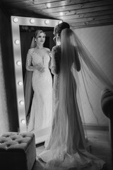 Elegant bride admires herself in mirror while preparing for wedding day