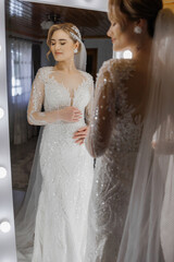 Bride prepares for wedding while admiring herself in mirror before ceremony