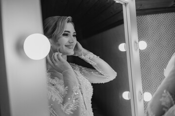 Bride preparing for wedding ceremony in elegant dressing room with bright lights