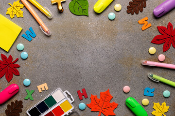 Bright frame with school supplies on dark rustic background with copy space for your design top view. Back to school concept.