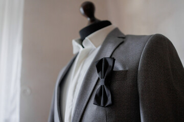 Elegant gray suit with bow tie displayed in a modern setting for formal occasions