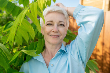 Closeup Portrait of Senior Woman Looking at Camera, Beautiful Face, Smiling. Elderly Lady with Natural Grey Hair, Blue Eyes. Abstract Beige Background, Tender and Soft Slow Motion