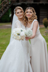 Elegant wedding moment featuring bride and maid of honor outdoors at a beautiful venue