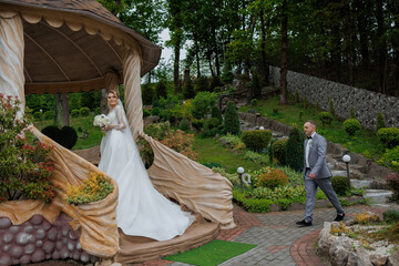 Couple celebrates love with enchanting outdoor ceremony near elegant gazebo in spring garden