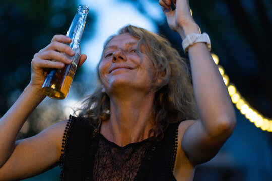 blured image of a woman dancing at a garden party or music festival