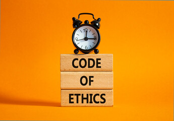 Code of ethics symbol. Concept words Code of ethics on wooden blocks with alarm clock. Beautiful...