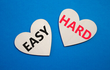 Easy or Hard symbol. Concept word Easy or Hard on wooden hearts. Beautiful blue background....