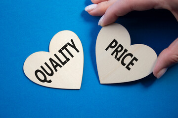 Price or Quality symbol. Concept word Price or Quality on wooden hearts. Businessman hand....