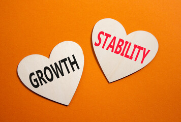 Growth and Stability symbol. Concept word Growth and Stability on wooden hearts. Beautiful orange...